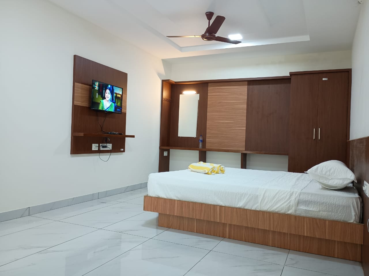 Aditya Inn Deluxe Room showcasing spacious layout, queen bed, and modern furnishings.